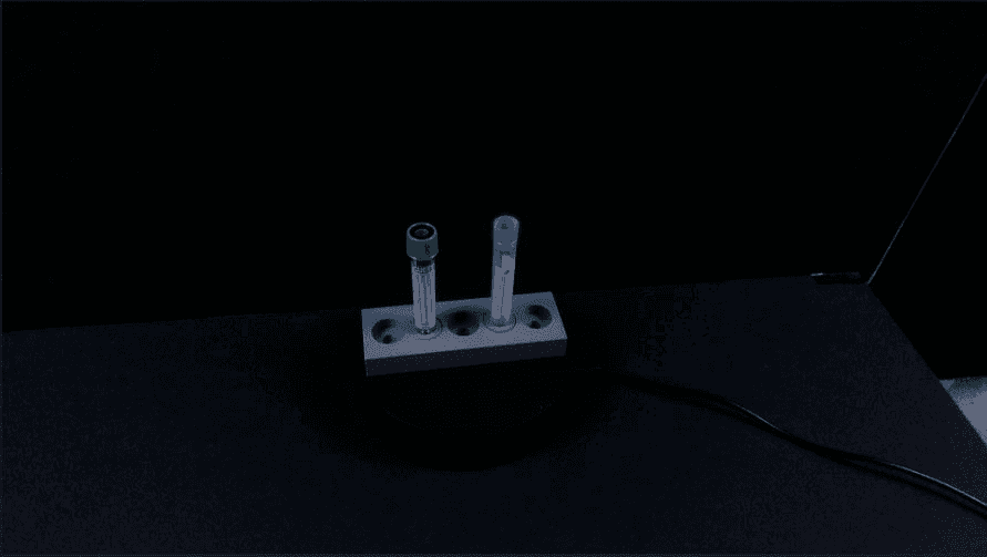 Two tubes in frame simultaneously — green cap left, blue cap right